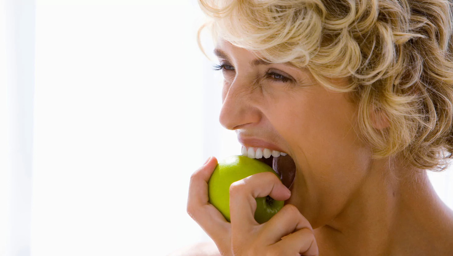 A patient confidently eating, representing strong, healthy teeth after treatment